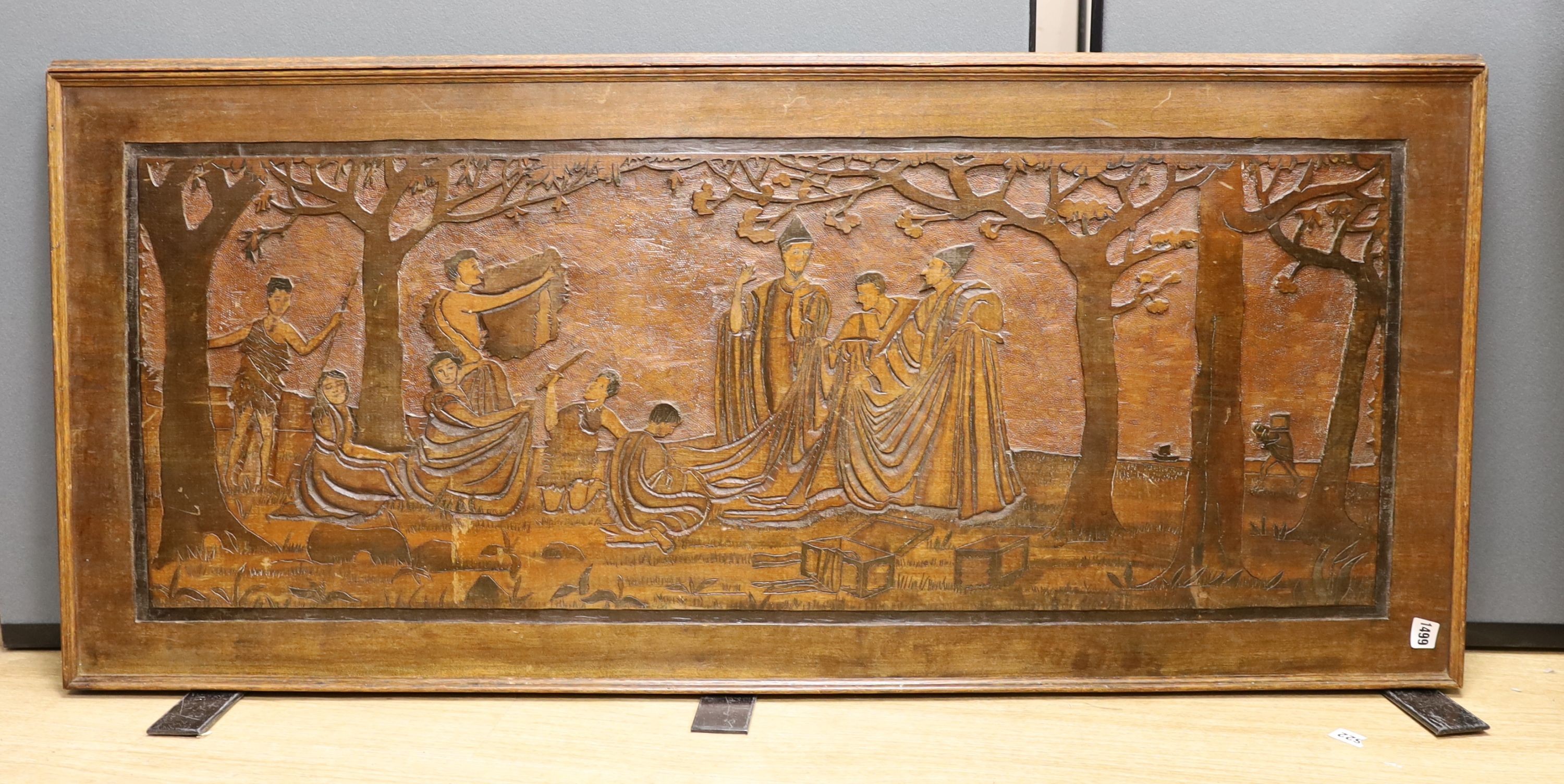 A large carved mahogany panel depicting Sir Frederic Leighton’s (1820-1896) painting which resides in The Royal Exchange London, ‘Phoenicians trading with the early Britons, on the coast of Cornwall’ 128cm x 58cm. *This